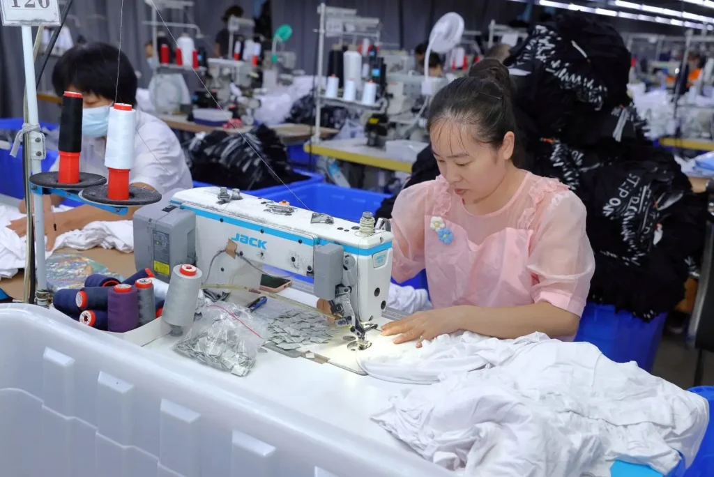 OEM clothing manufacturer workers producing custom apparel in factory