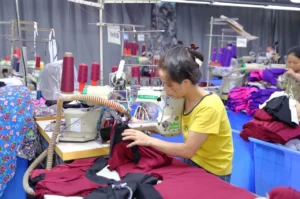 Skilled factory worker stitching a custom sample on a precision sewing machine for an online sample order.