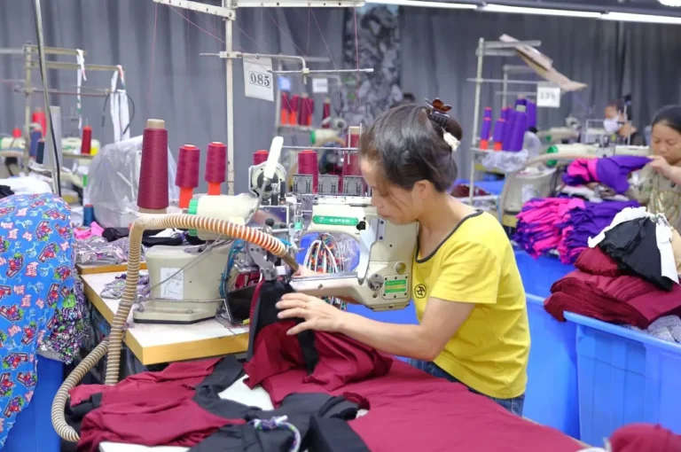 Skilled factory worker stitching a custom sample on a precision sewing machine for an online sample order.