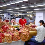 At a custom underwear factory in China that supports low minimum order quantities (MOQs), several skilled garment workers are inspecting the quality of men's boxer briefs.