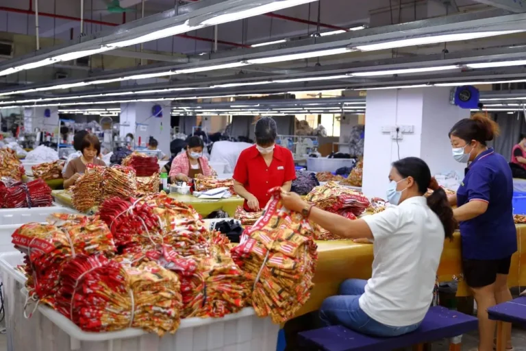 At a custom underwear factory in China that supports low minimum order quantities (MOQs), several skilled garment workers are inspecting the quality of men's boxer briefs.