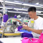 Skilled technician sewing a custom fabric sample on a specialized machine for an underwear manufacturing sample request.
