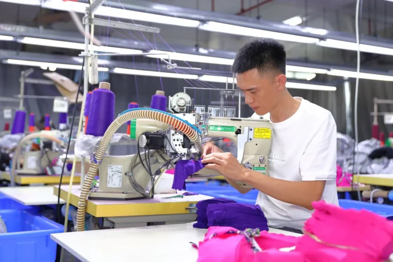 Skilled technician sewing a custom fabric sample on a specialized machine for an underwear manufacturing sample request.
