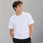 Male model wearing a plain white T-shirt for custom T-shirt manufacturing
